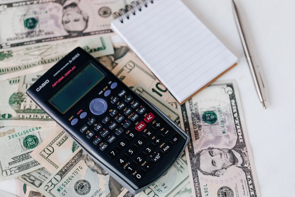 A calculator on top of USD bank notes to signify that portfolio loan terms and fees may vary. 