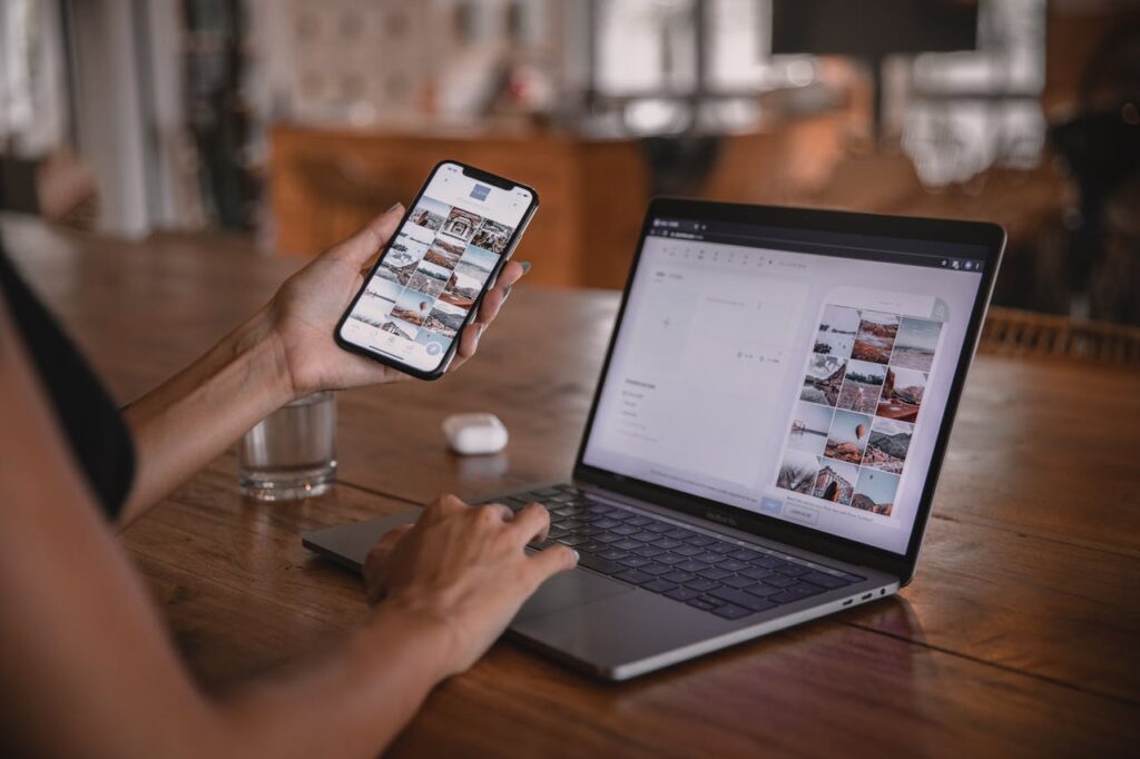 An influencer, who would be a great candidate for a Georgia bank statement loan, is looking at photos on her phone and computer. 