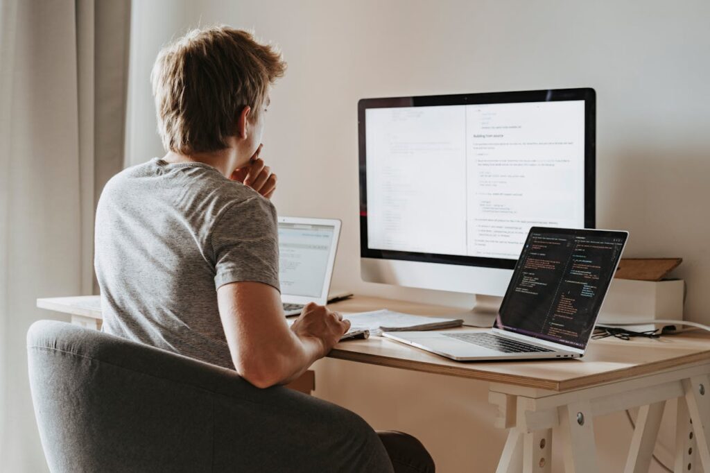 A man is sitting at his desk in front of his computer, comparing his options for mortgages for vacation homes.