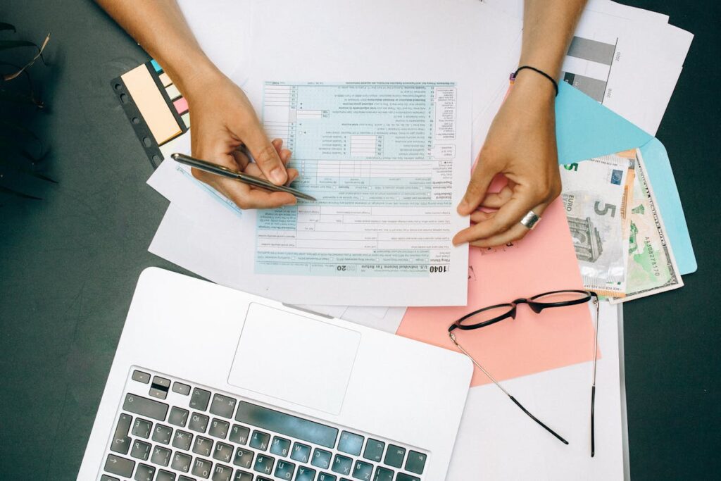 A top-down view of someone preparing their tax return, which is one of the main differences between QM vs. non-QM mortgages.