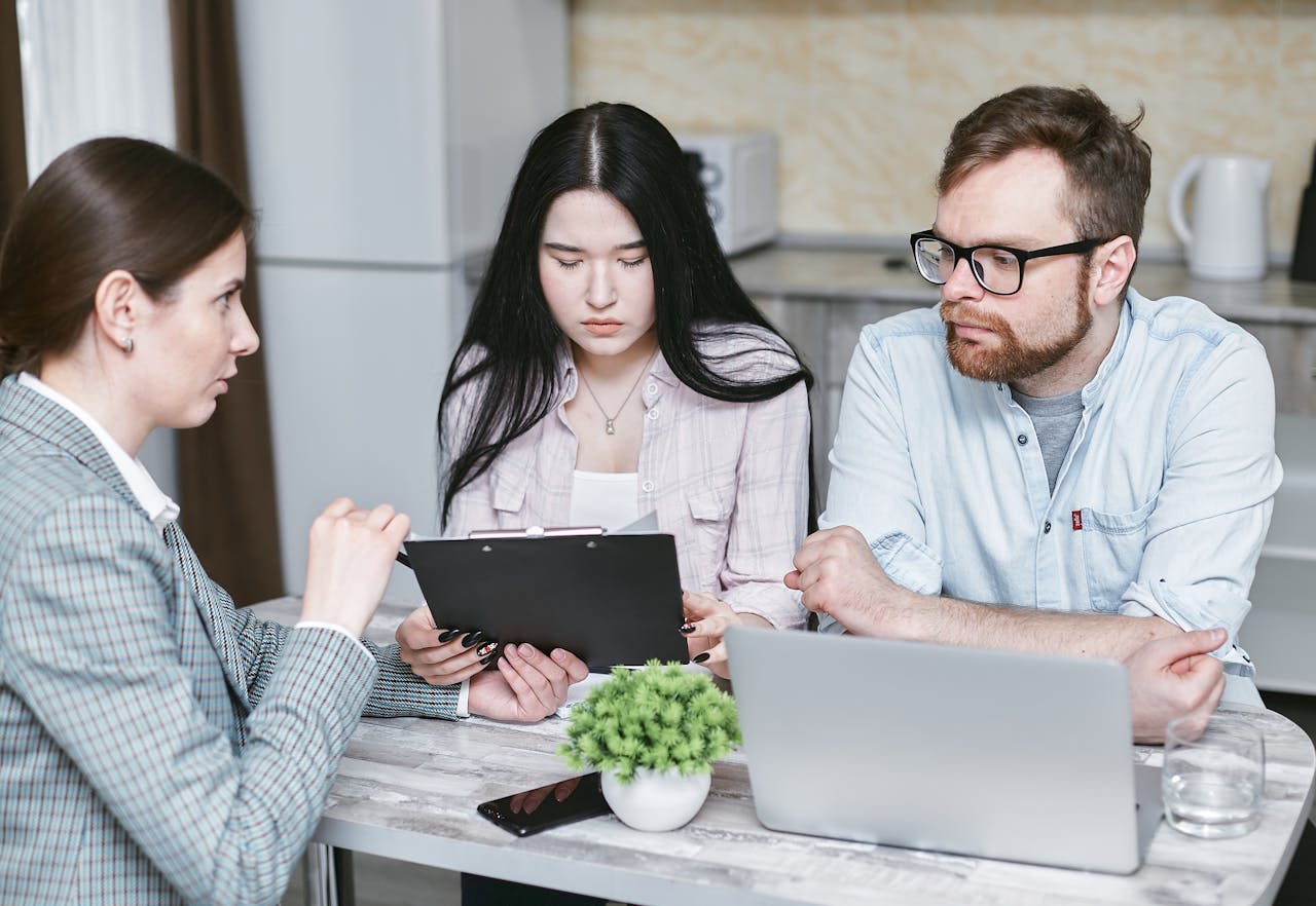 A couple is meeting with a loan officer to discuss their options between QM vs. non-QM mortgages.