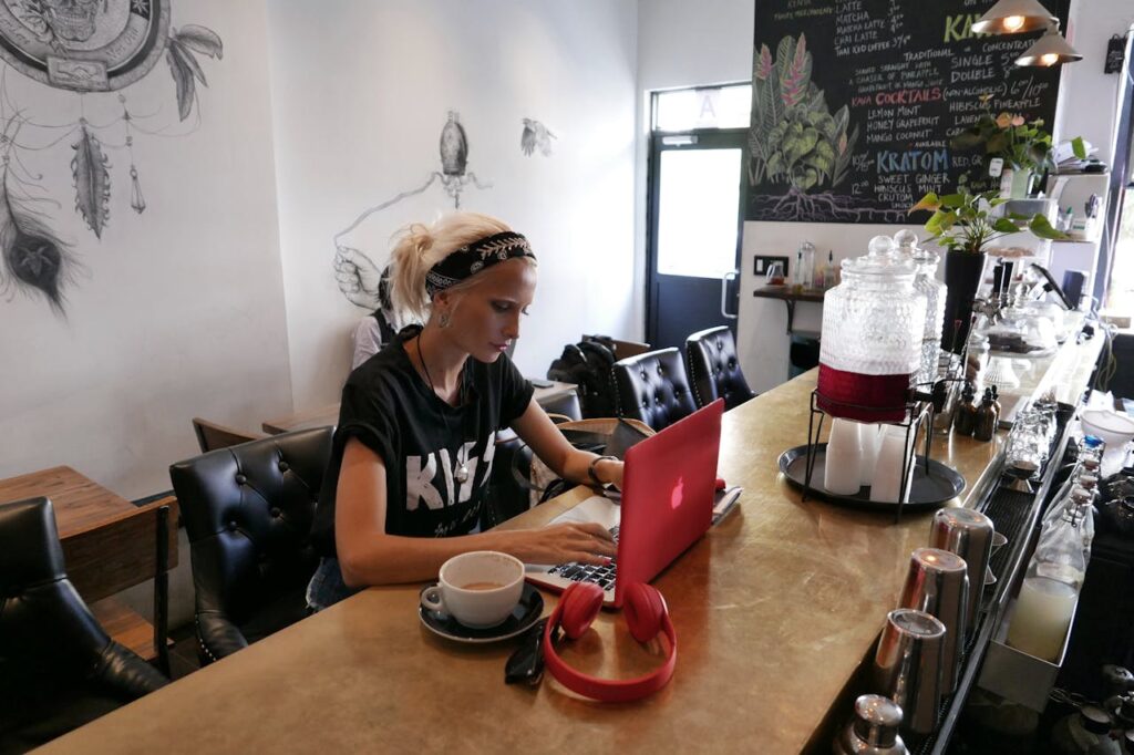 A restaurant owner is applying for a Tennessee P&L loan on her laptop while sitting at the bar.