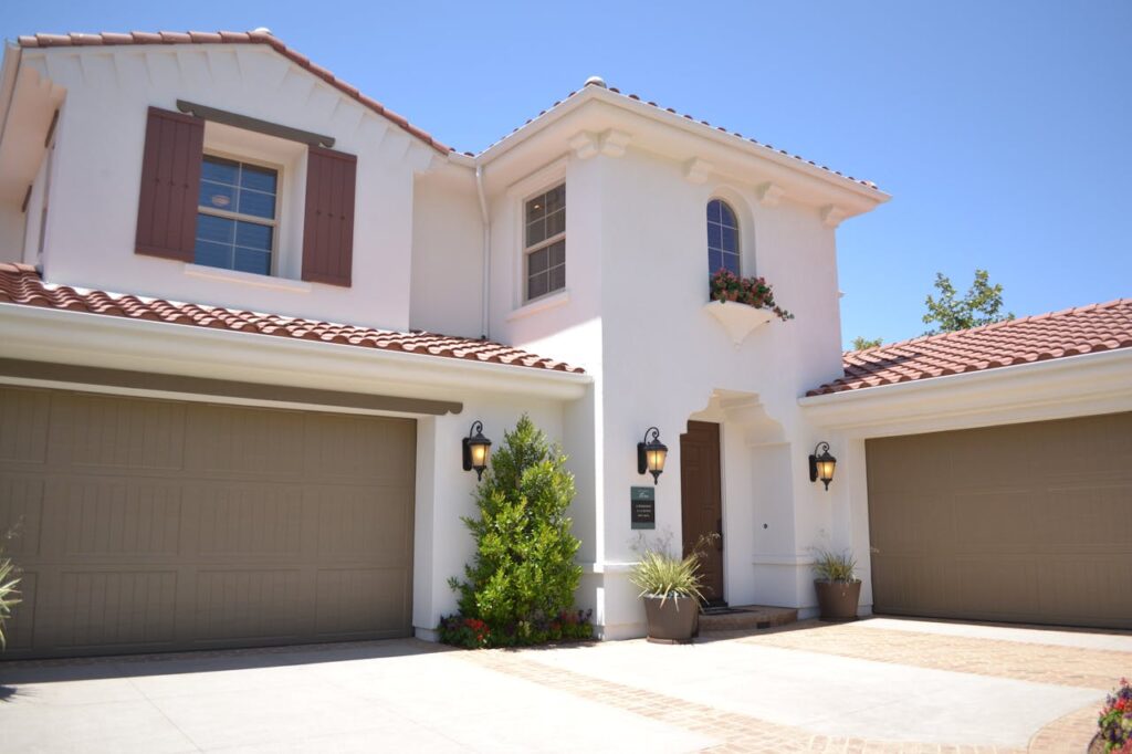 A white concrete home with a red clay roof. 