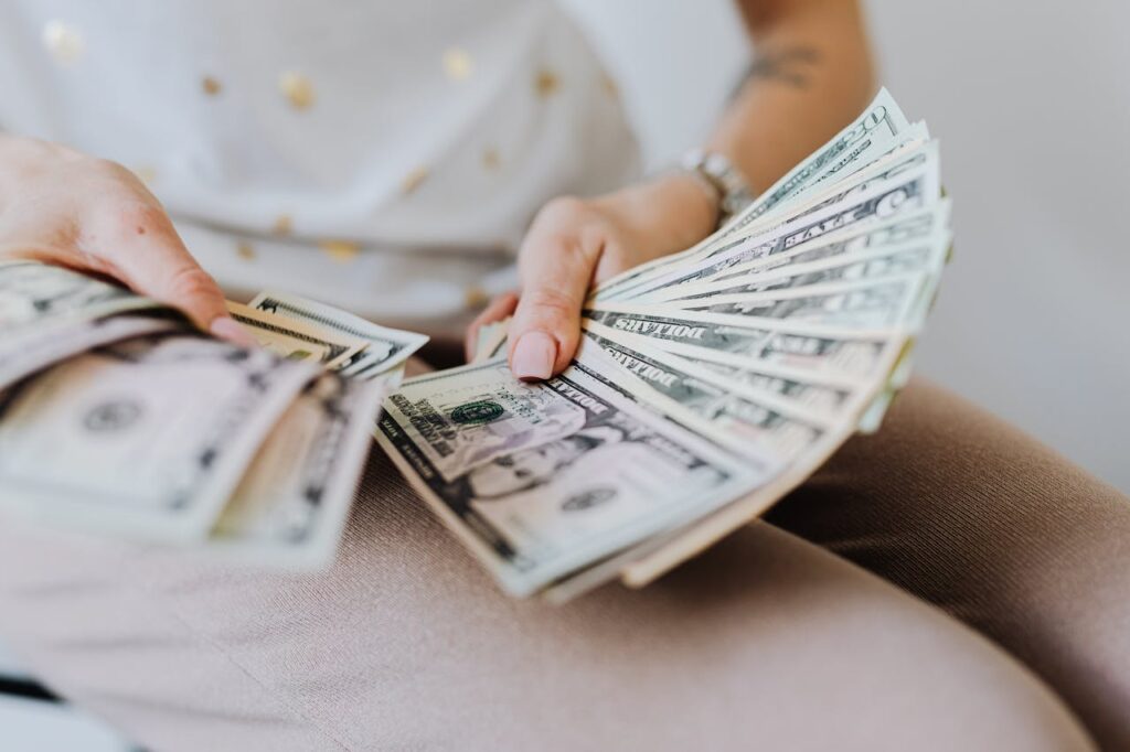 A woman counting cash that she got from a cash-out refinance. 