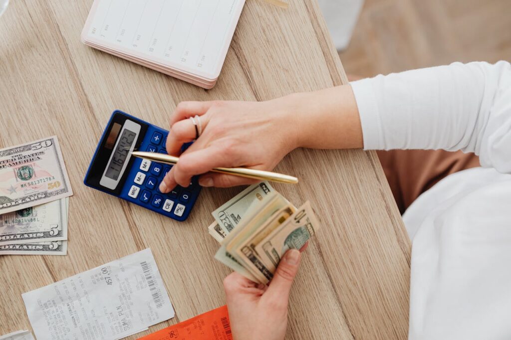 A woman is punching numbers into a calculator to see how much cash she could get from a cash-out refinance for investment properties. 