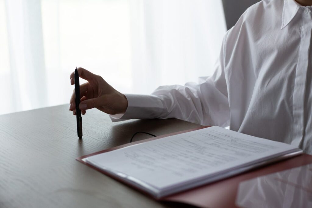 A homebuyer is sitting at a desk reviewing a copy of the home inspection report. 