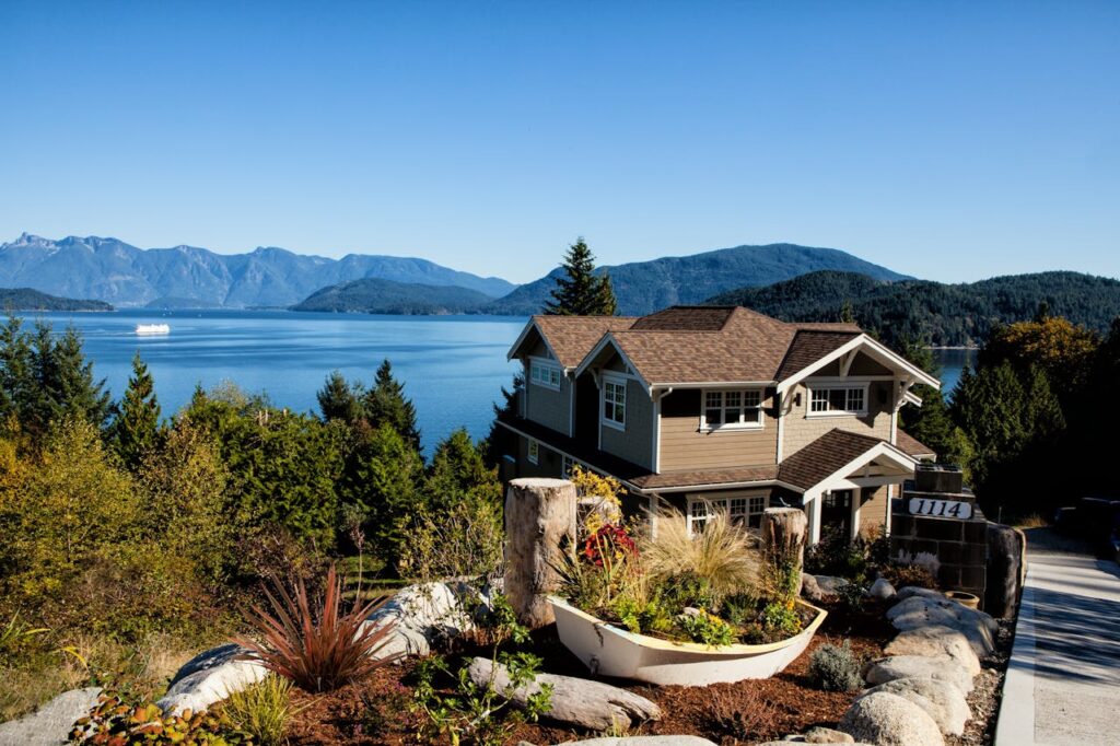 A vacation home in Washington state that's located up on a hill with a view of a lake and mountains in the distance. 