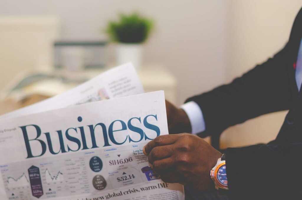 A real estate investor in a suit is reading the business section of a newspaper to stay up-to-date on the Federal Reserve interest rate cuts. 