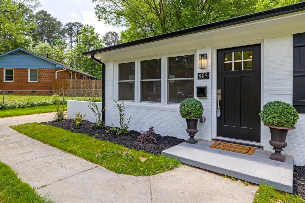 The front door of a modern farmhouse style ranch that was refinanced after the Federal Reserve interest rate cuts. 