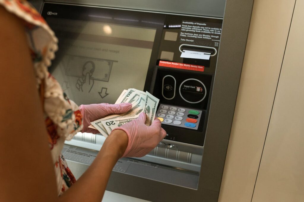 A woman is taking cash out of the ATM from her HELOC, a form of home equity loan. 