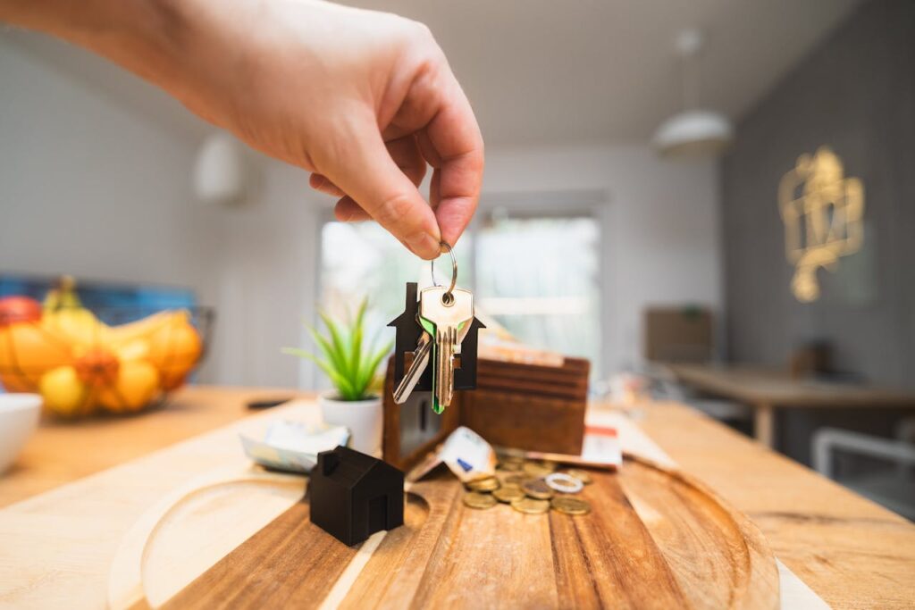 A person holding up keys to their new home that was purchased with an FHA loan application. 