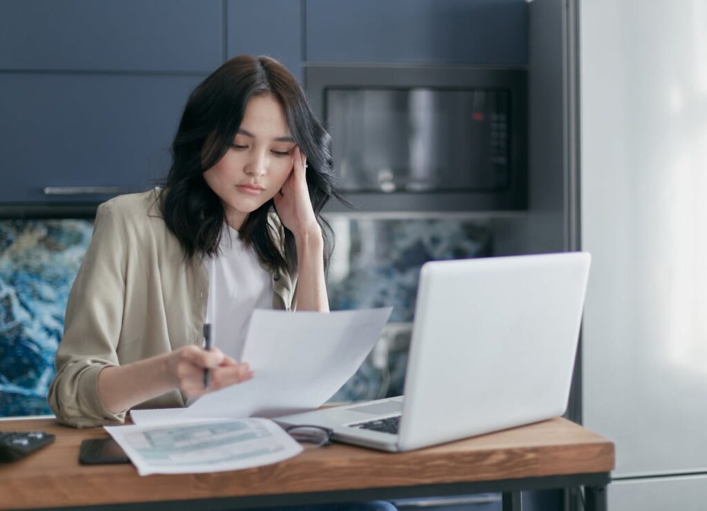 A young woman is reviewing her personal documents to see if she can qualify for an FHA loan application. 