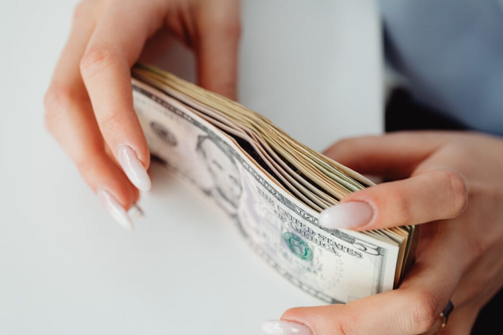 A woman is stacking bank notes of the cash she received from a bank statement home equity loan. 