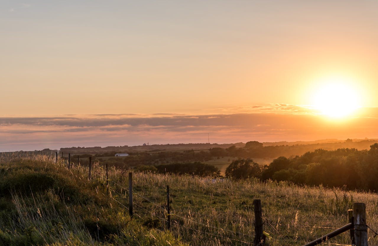 A sunset over a field in Nebraska, which is a state full of investment opportunity with a DSCR loan Nebraska.