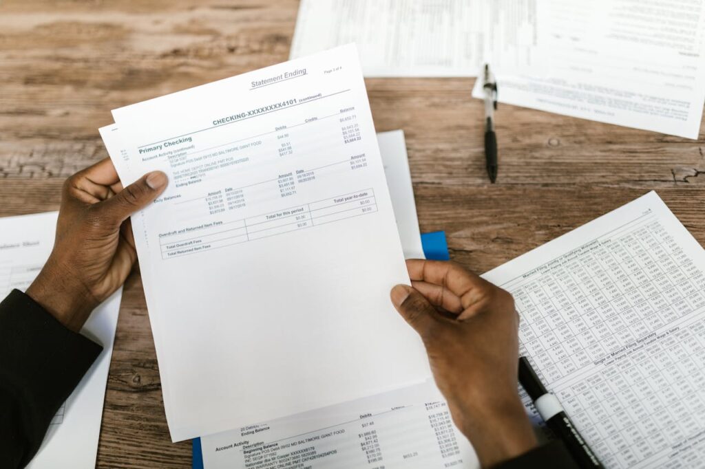 A man holding his bank statement and reviewing it, so he can apply for a bank statement loan, which is under the home loans for unemployed borrowers umbrella. 