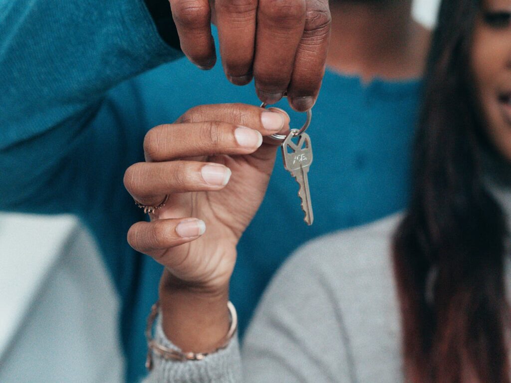 A couple holding their new house key after looking up todays current mortgage loan rates.