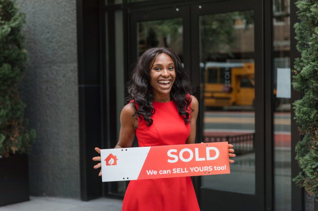 A realtor is holding a "sold" sign after her client chose a non-traditional mortgage lender. 