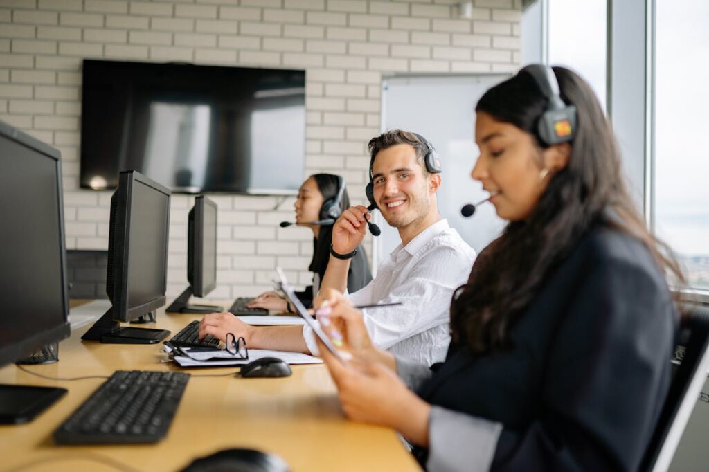 A call center worker at a mortgage lender is smiling at the camera and helping customers determine where to get a mortgage.