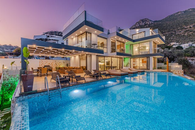 A backyard view of a luxury property investment that has a pool and open-air concept.